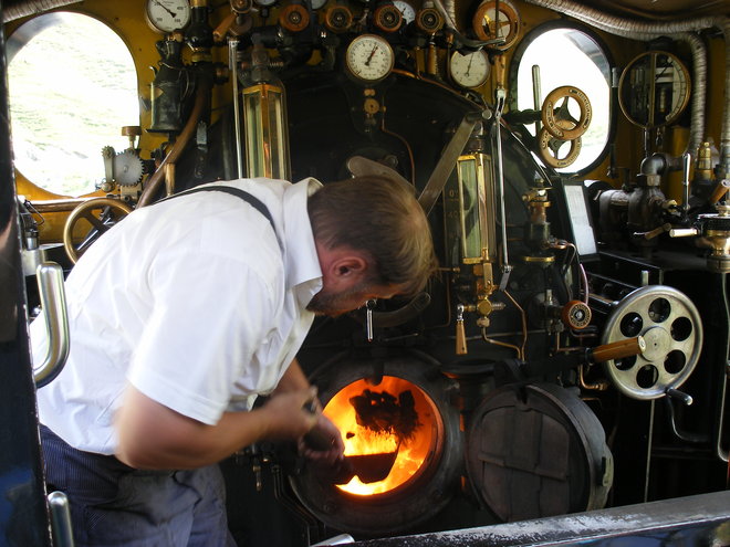 La dernière seconde d'existence pour cette pelletée de charbon jetée dans les flammes du foyer de la HG 130 T ex-BFD N°4 sur la ligne de la Furka.JPG
