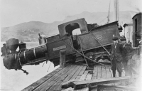 Accident showing steam engine hanging half over the edge of Lyttelton wharf, having been dropped from a crane while being loaded or unloaded