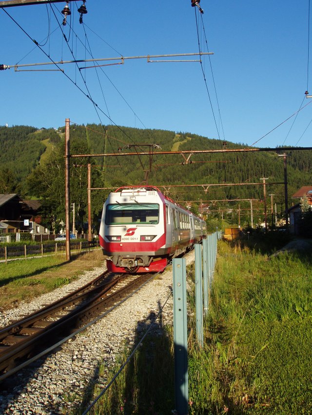Une rame automotrice composée de 2 motrices 4090 et d'une remorque 7090 arrive à Mariazell dans la lumière du soir