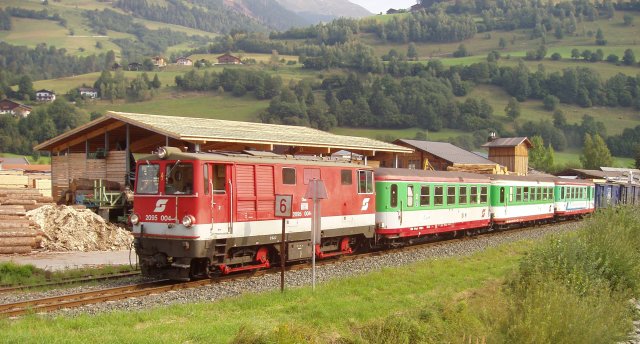 La BB 2095.004 en tête d'un train longe une scierie