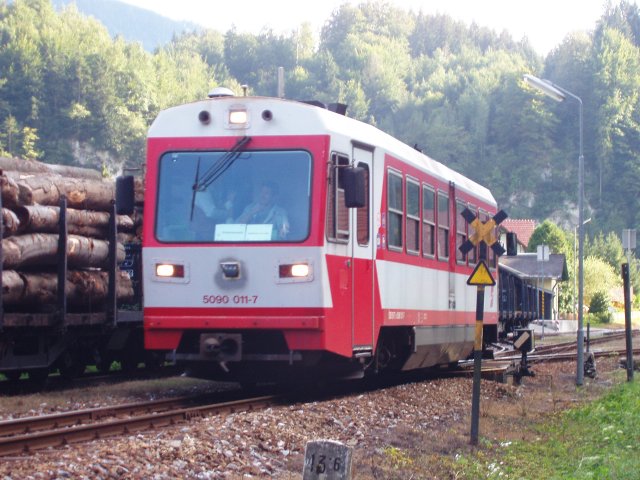 Départ de l'autorail longeant une rame de grumiers en gare d'Opponitz